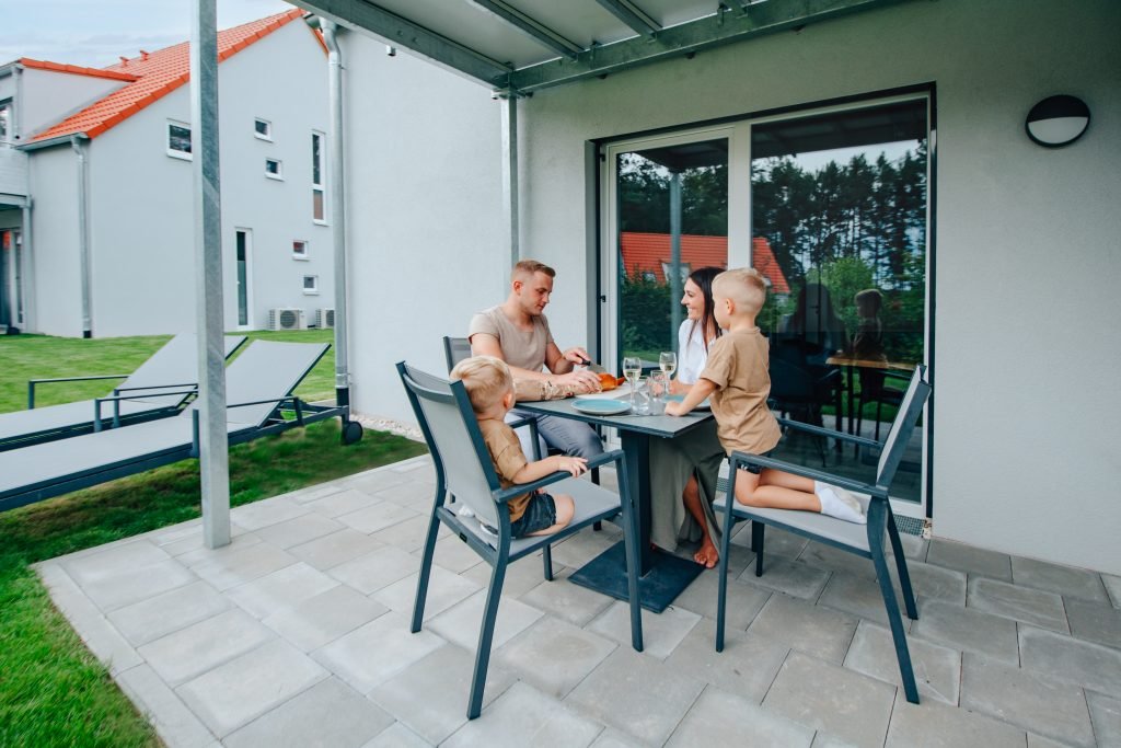 Eine Familie sitzt am Tisch auf einer Terrasse