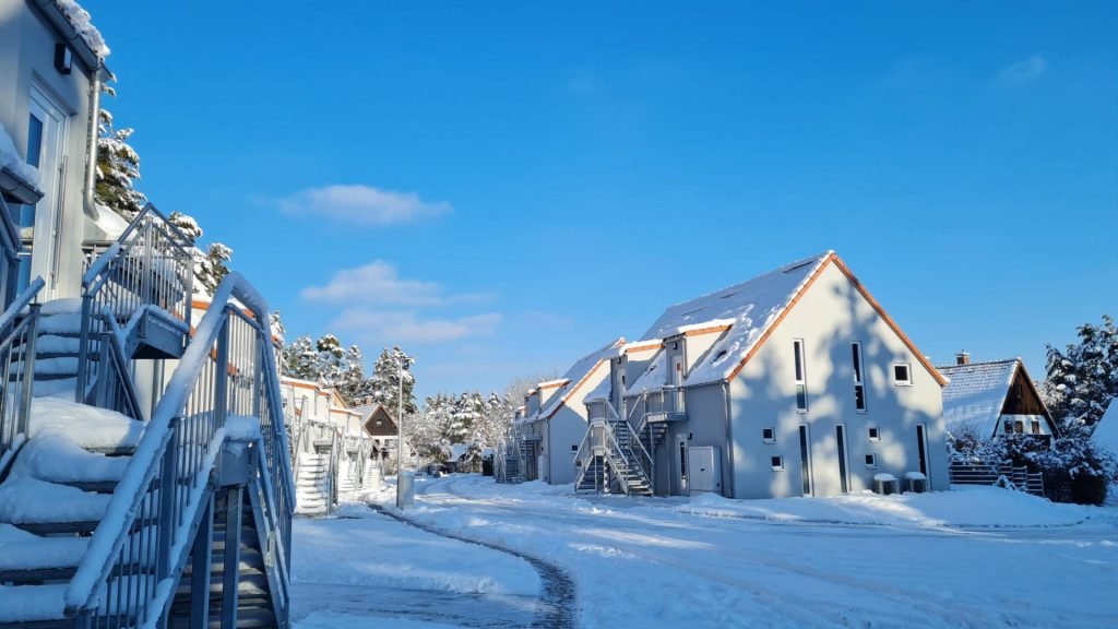 Verschneite Ferienhäuser an einem sonnigen Wintertag